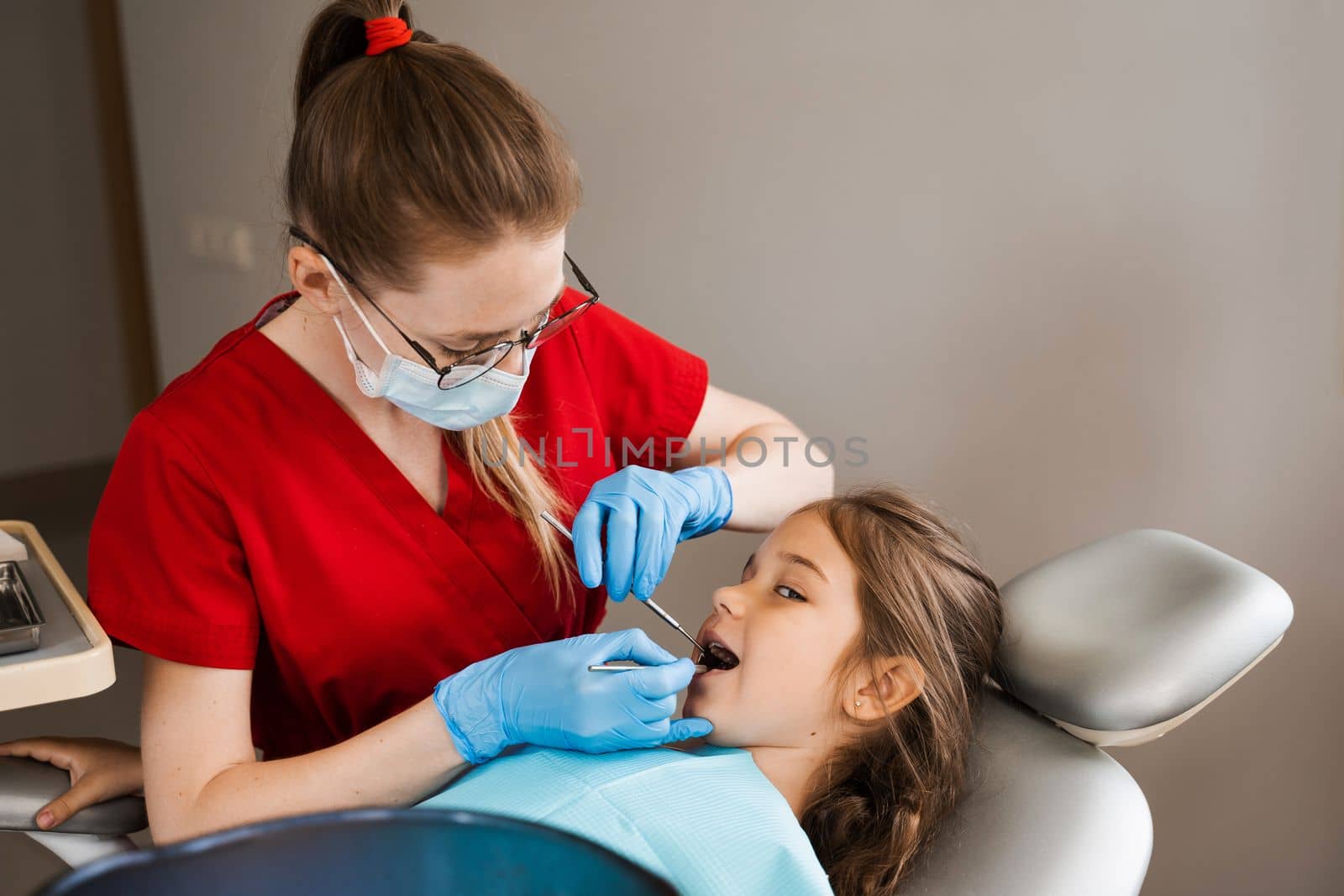 Cheerful child girl smiling at dentists consultation in dentistry. Dental diseases. Consultation with pediatric dentist for treatment of toothache in child. by Rabizo