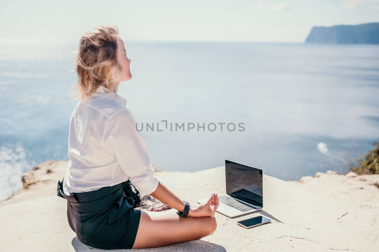 Woman sea laptop yoga. Business woman freelancer in yoga pose working over blue sea beach at laptop and meditates. Girl relieves stress from work. Freelance, digital nomad, travel and holidays concept by panophotograph