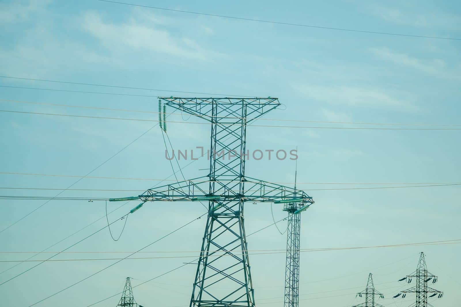 Silhouette High voltage electric tower on sunset time, distribution electric substation with power lines and transformers.