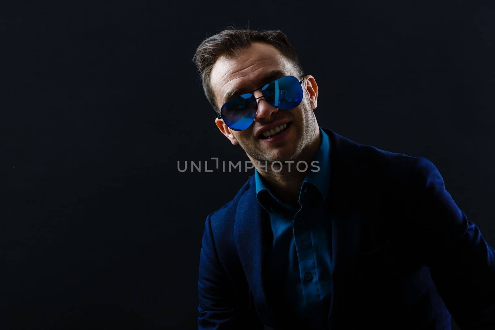 Portrait of attractive cheerful gentleman posing isolated over dark color background by Andelov13