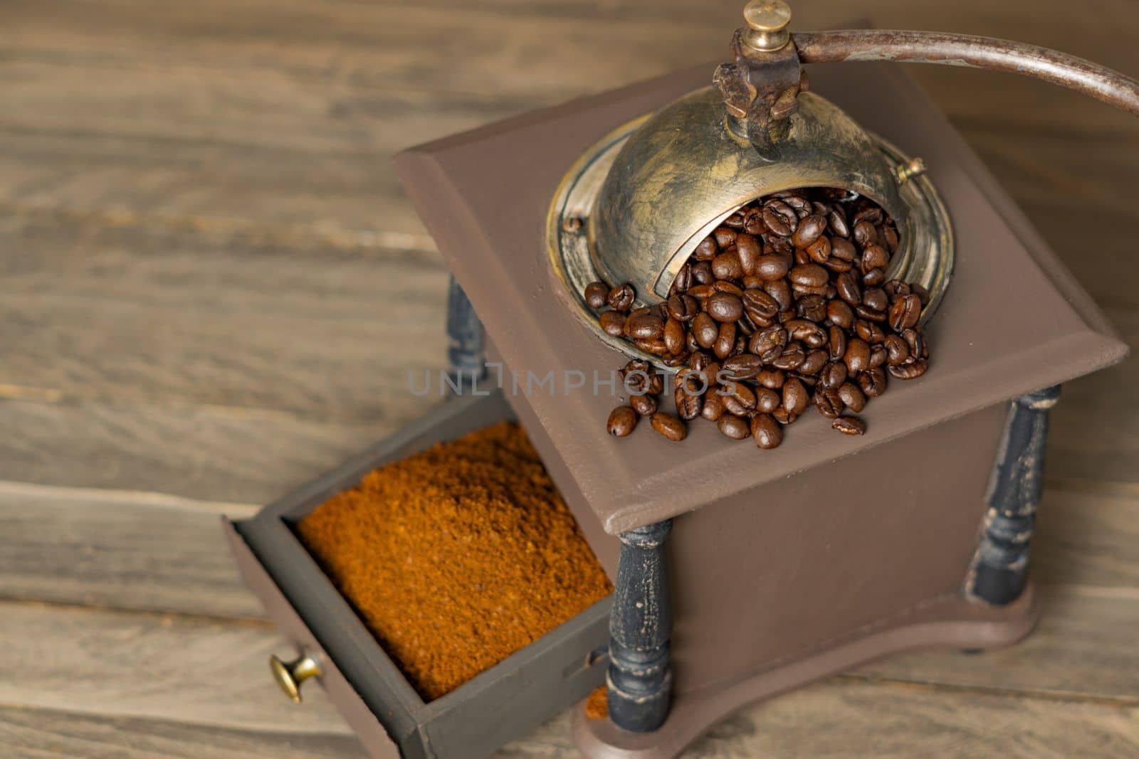 antique coffee grinder with coffee beans and ground coffee