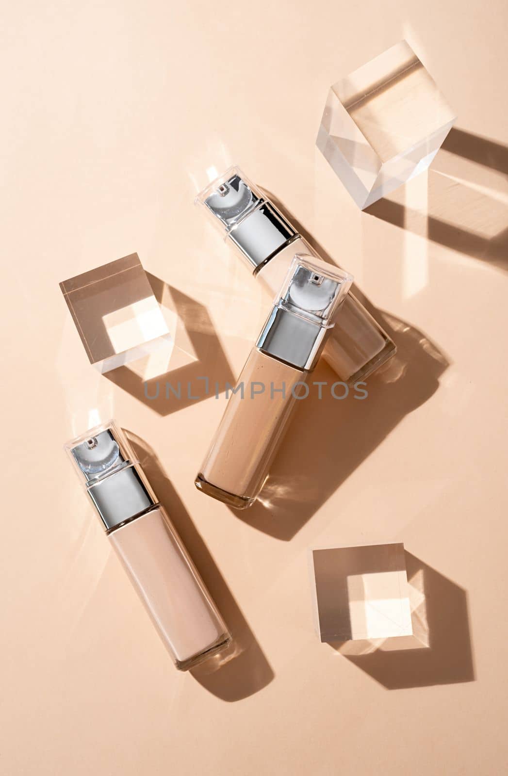 luxury glass bottles with foundation base beauty make up product , mockup design with glass prisms and podiums on beige background