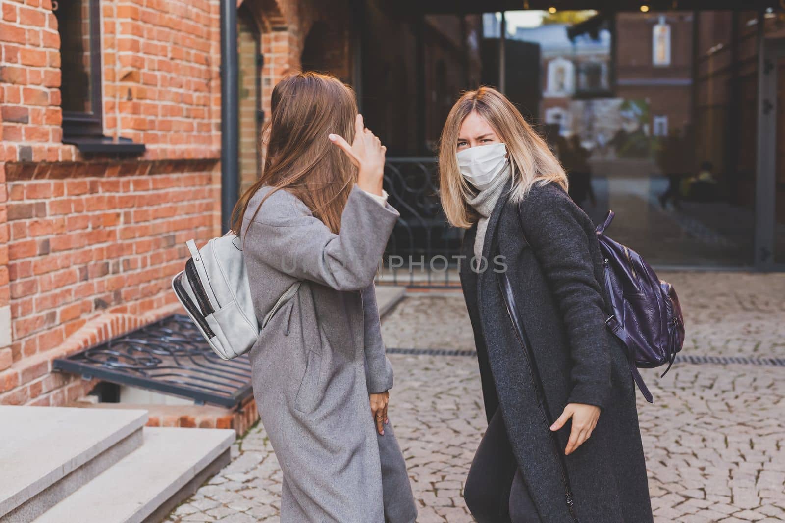 Young pretty girls friends having fun outdoor in autumn evening in city laughing and going crazy on the street - friendship and funny people