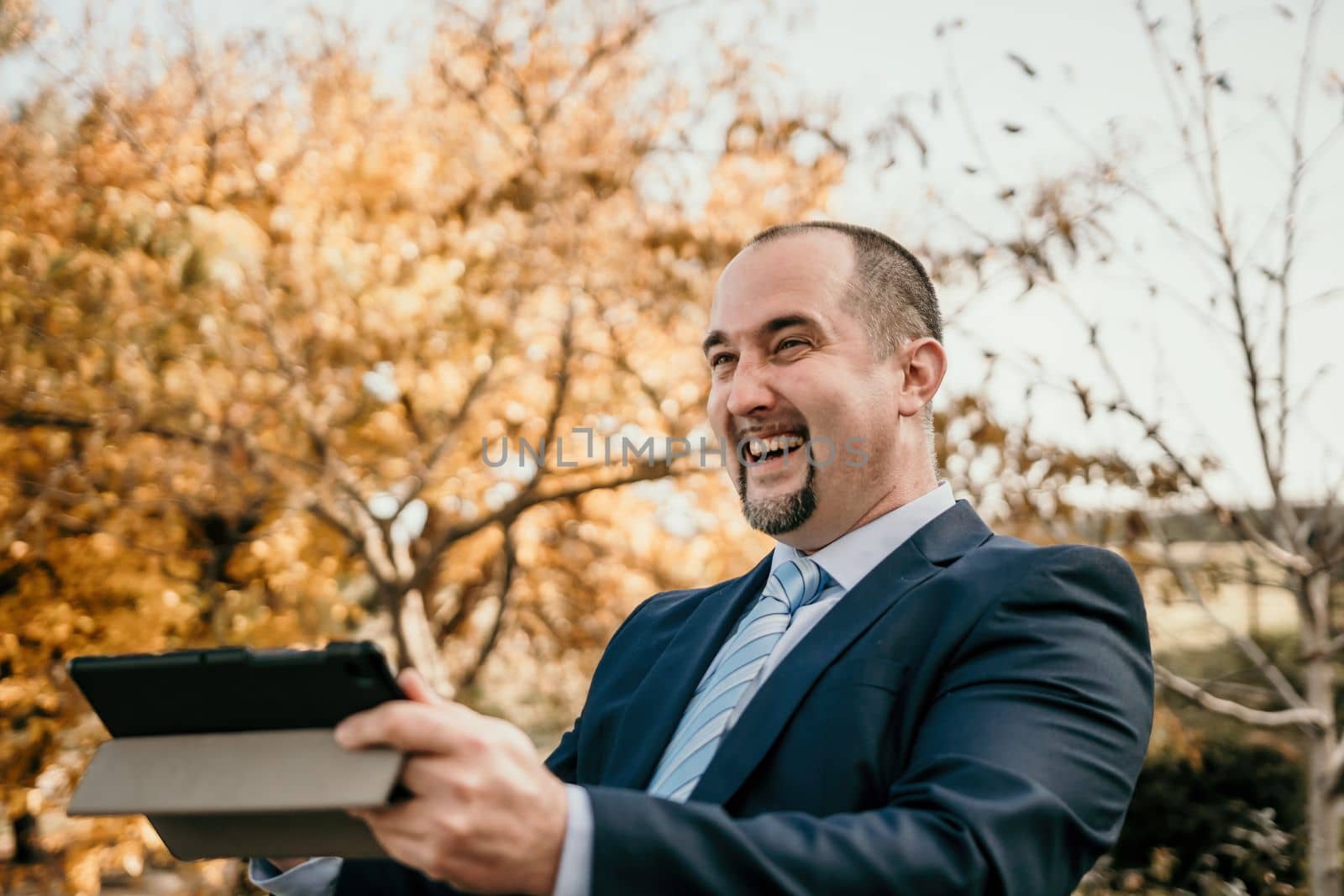 Mature entrepreneur drink coffee in autumn park. Senior executive rest in city park.