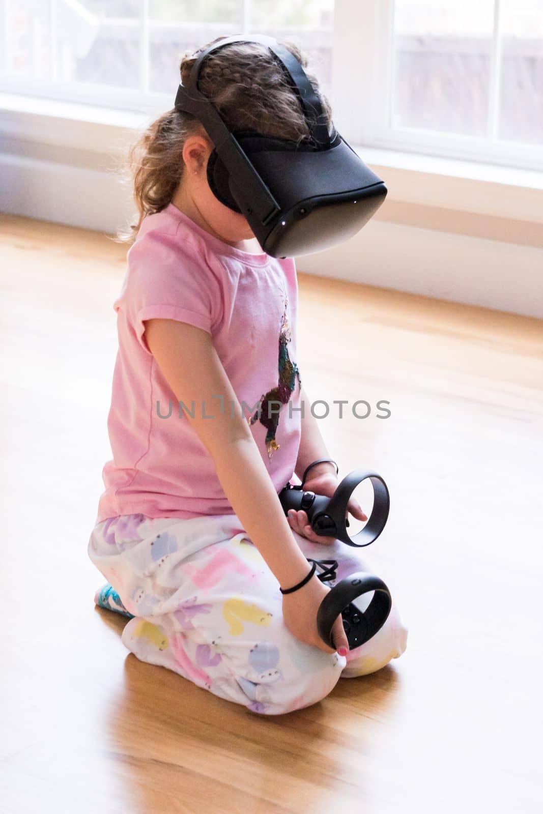 Little girl playing virtual reality game in the living room,