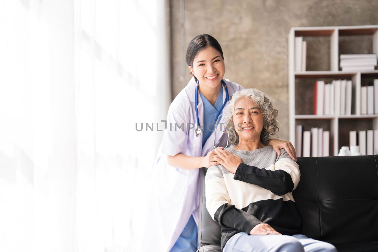 Young caregiver helping senior woman walking. Nurse assisting her old woman patient at nursing home. Senior woman with walking stick being helped by nurse at home...