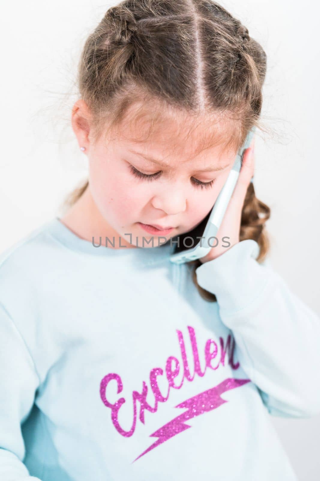 Little girl talking on the phone with her school friends.