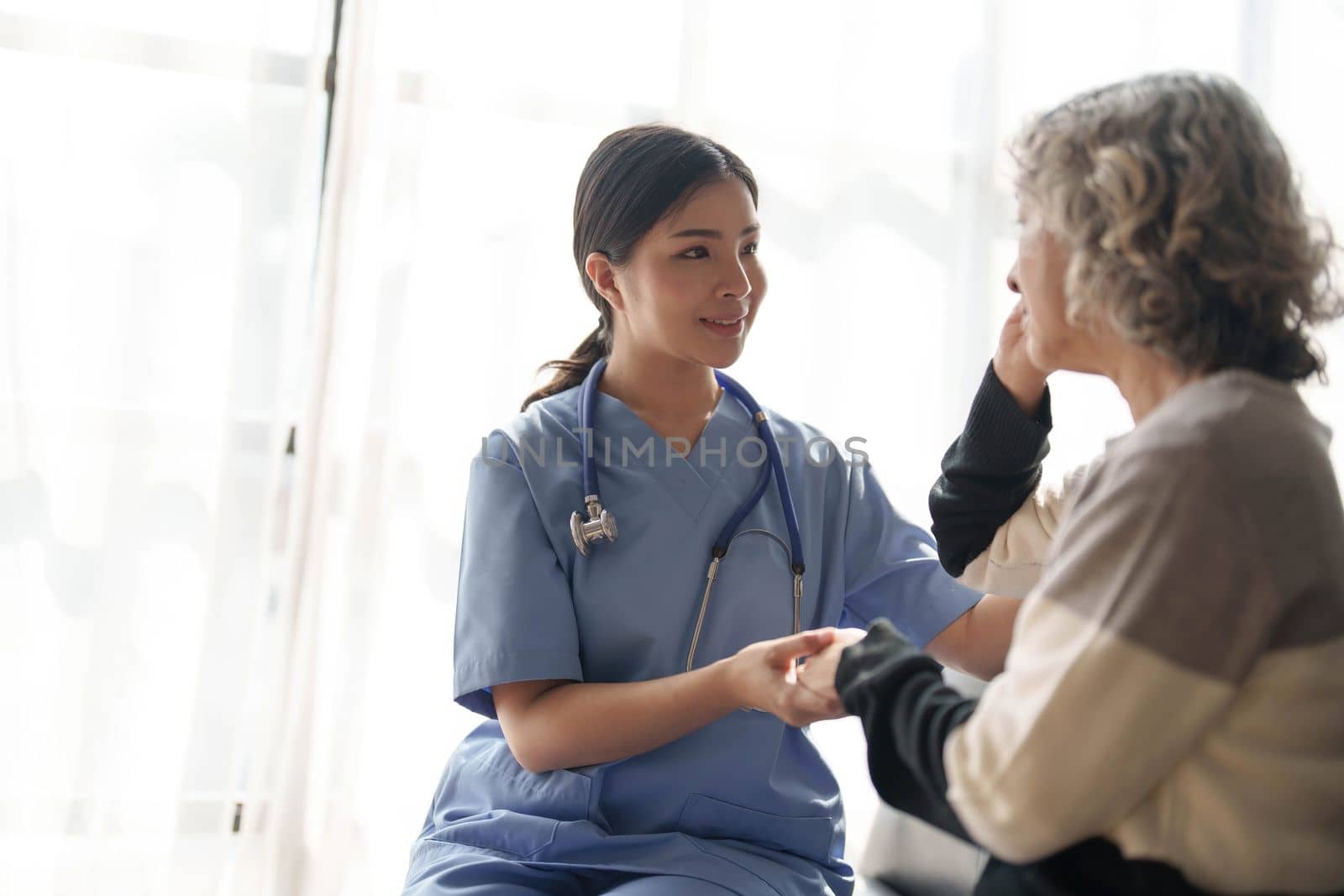 Young caregiver helping senior woman walking. Nurse assisting her old woman patient at nursing home. Senior woman with walking stick being helped by nurse at home...