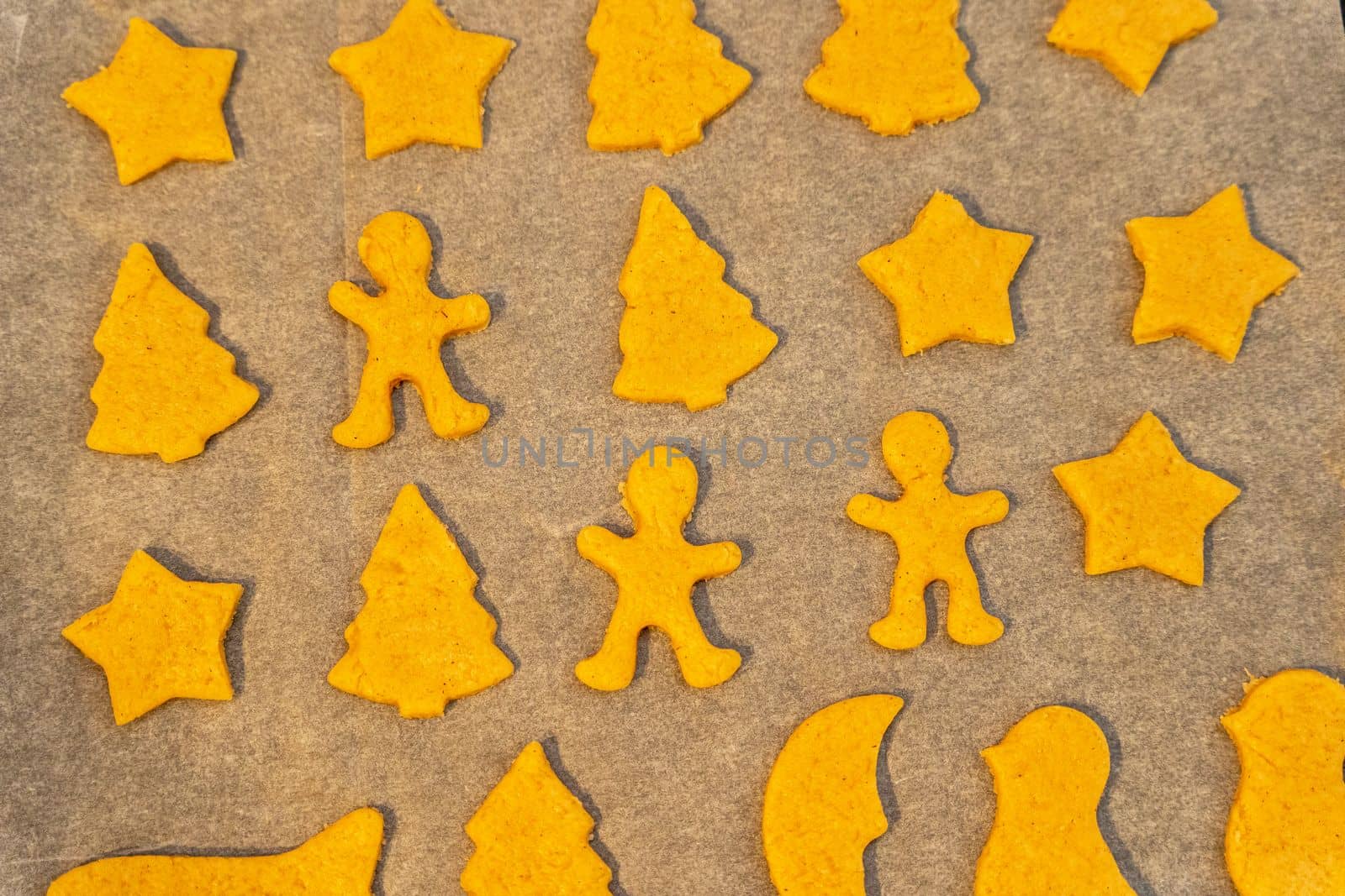 unbaked cookies on a baking sheet from the oven, close-up of various shapes of cookies. figurines, cookies, baking sheet, baking paper. background