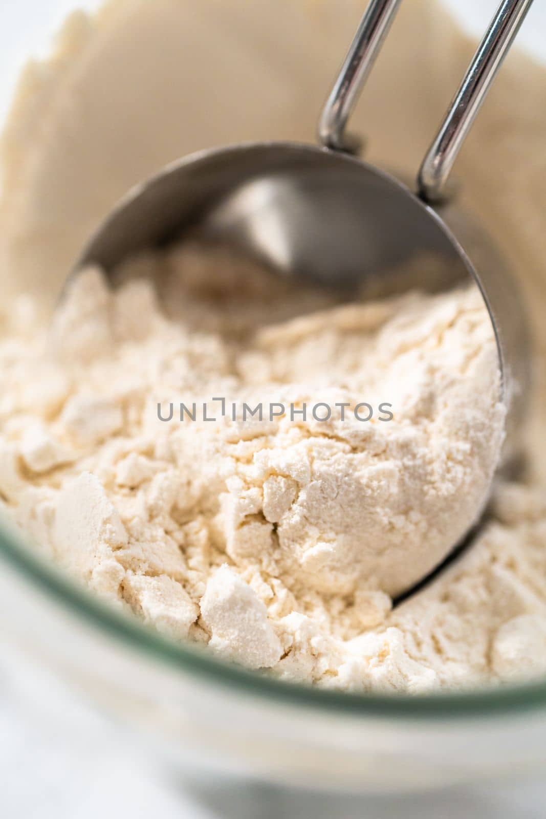 Measuring cup inside glass jar filled with all-purpose flour.