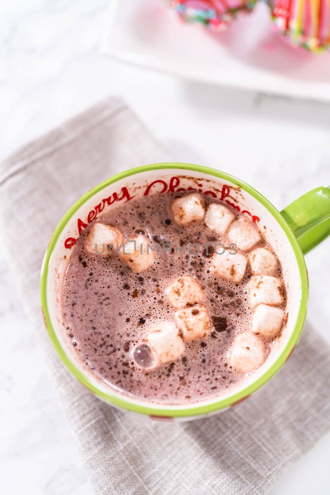 Preparing Christmas hot chocolate bombs with hot milk in a Christmas mug.