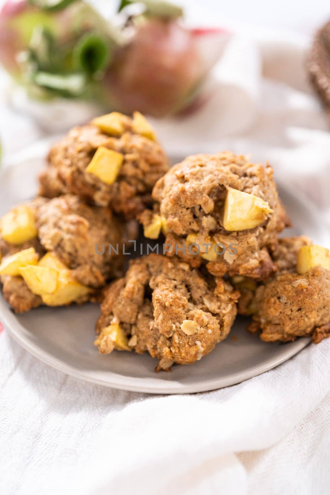 Freshly baked apple oatmeal with apple chunks cookies on small plate.