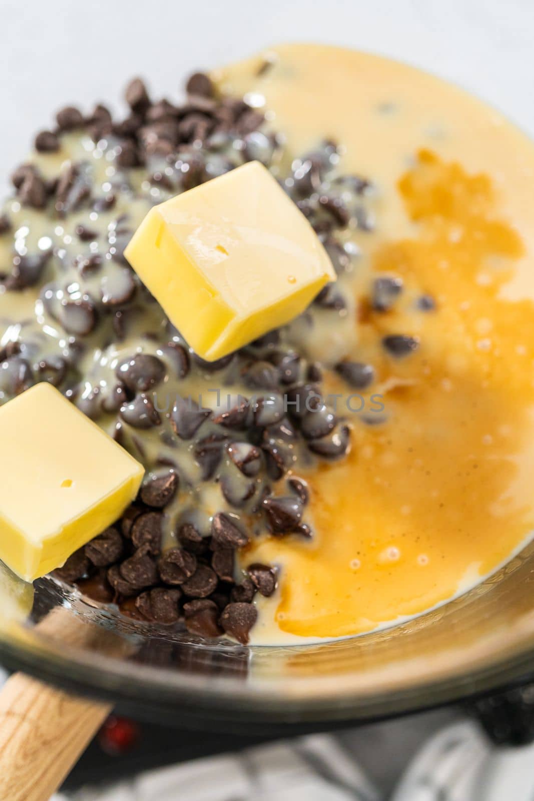 Melting white chocolate chips and other ingredients in the double boiler to prepare chocolate pistachio fudge.
