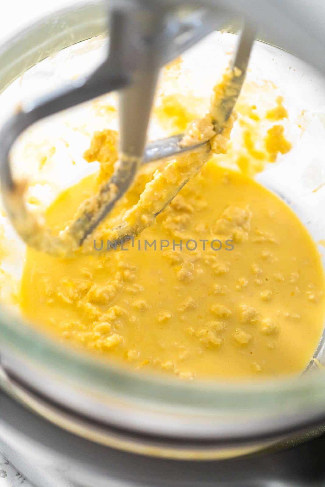 Mixing ingredients in kitchen mixer to bake mini Easter bread kulich.