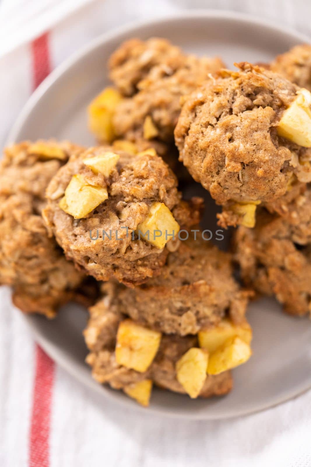 Freshly baked apple oatmeal with apple chunks cookies on small plate.