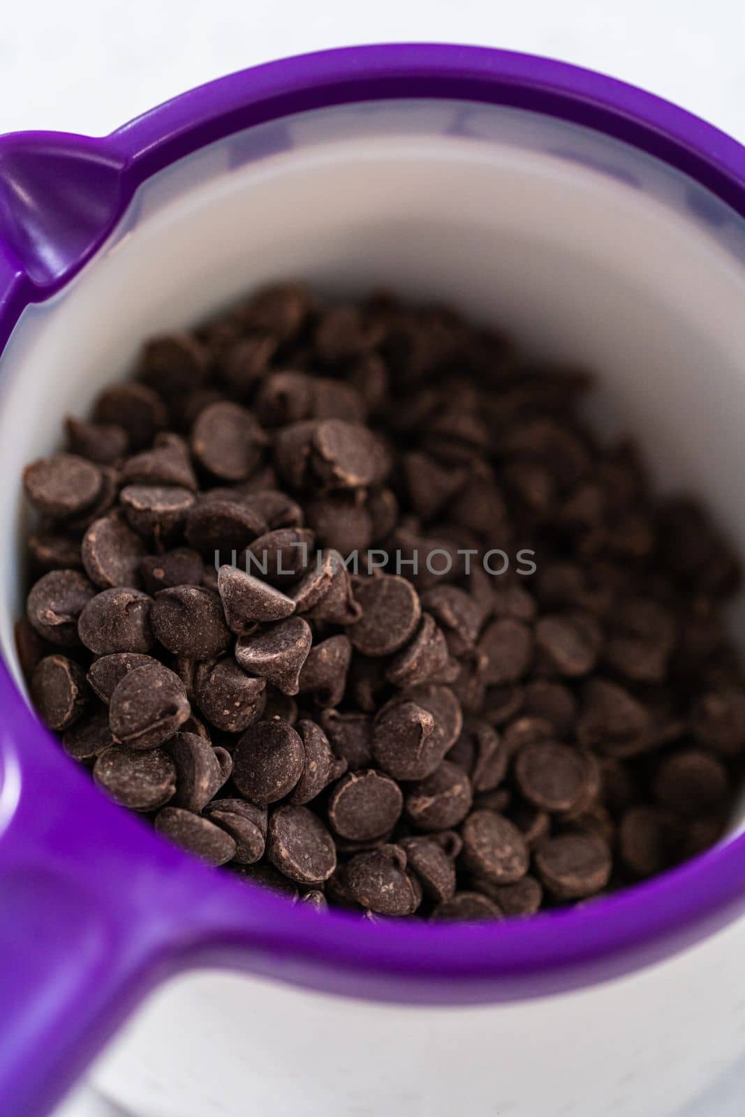 Melting chocolate chips in a candy melting pot to make chocolate-covered pretzel rods.