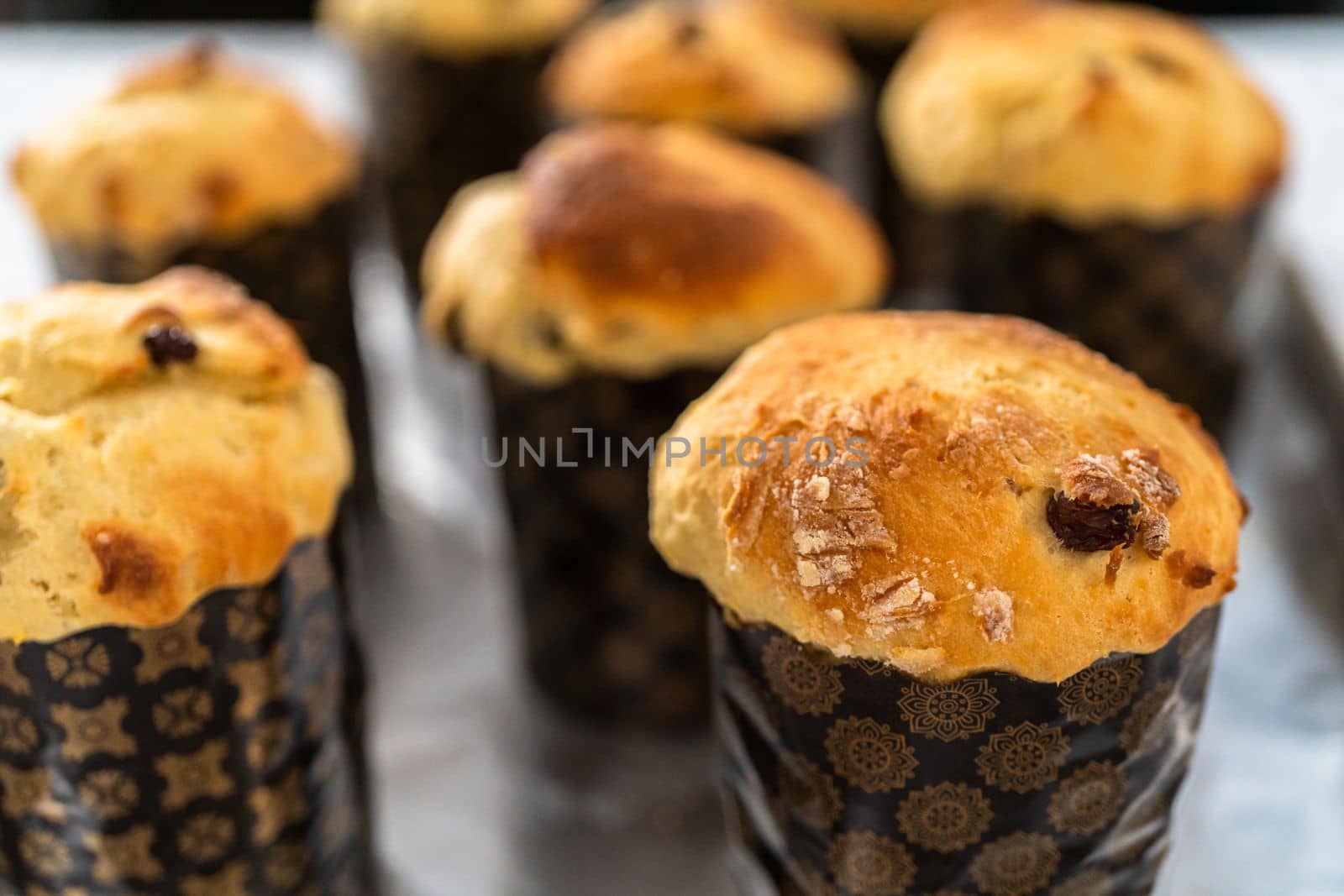 Cooling freshly baked mini Easter bread kulich on a kitchen counter.