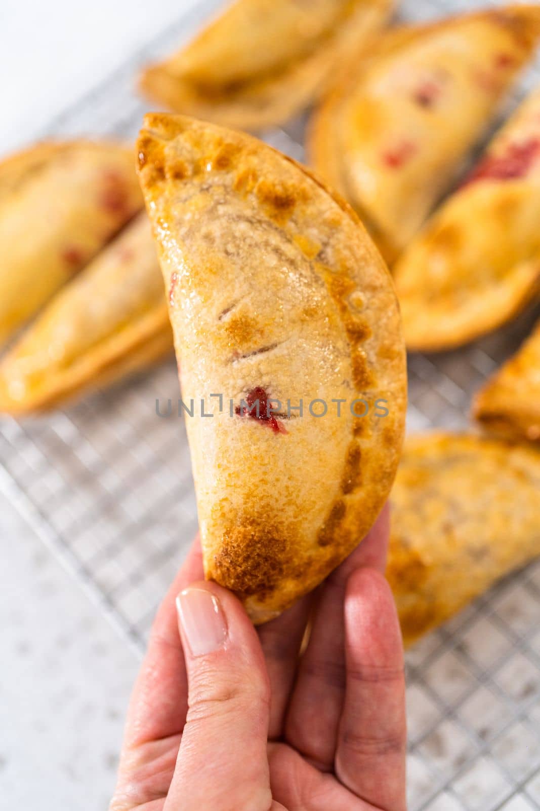 Freshly baked sweet cherry empanadas in the air fryer on the kitchen counter.