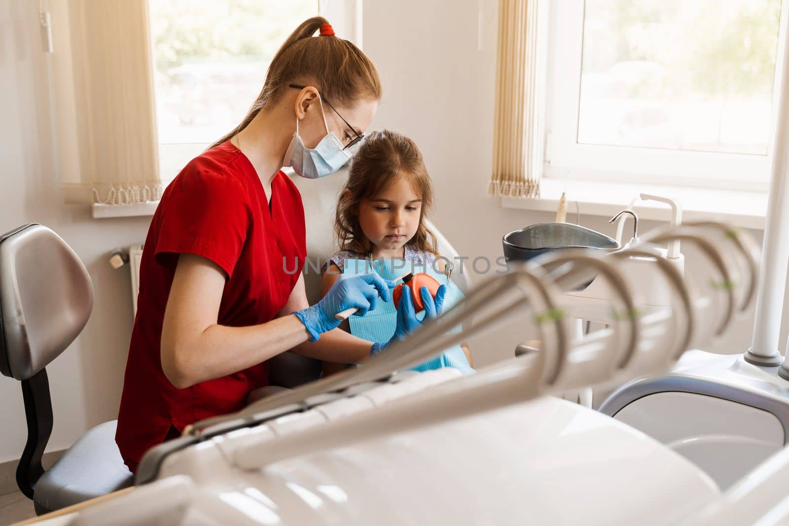 Oral hygiene lesson of jaw anatomical model for child in dentistry. Dentist shows child how to properly brush his teeth with a toothbrush