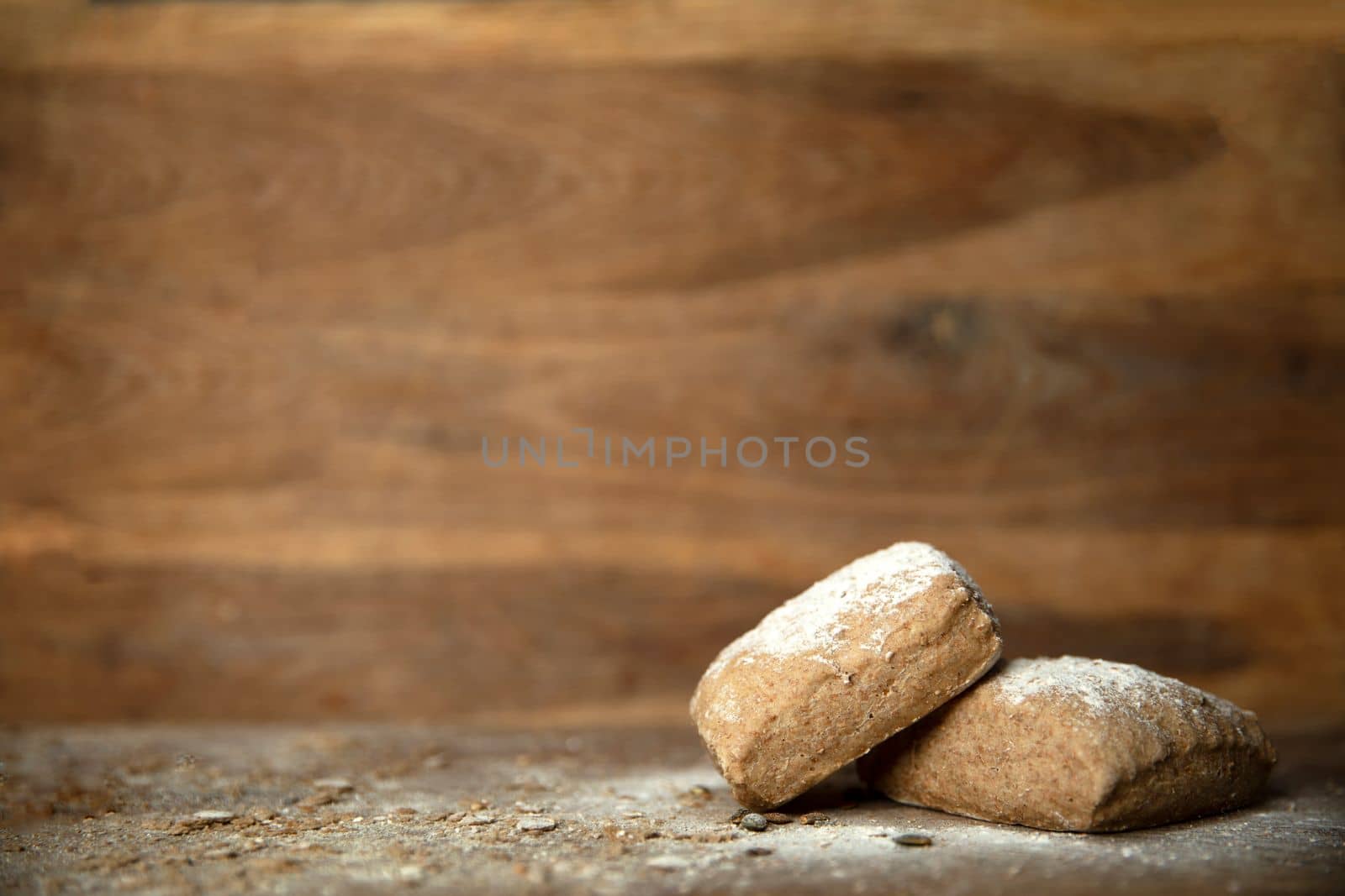 Fresh baked bread with flour on wooden table and background with copy space close up