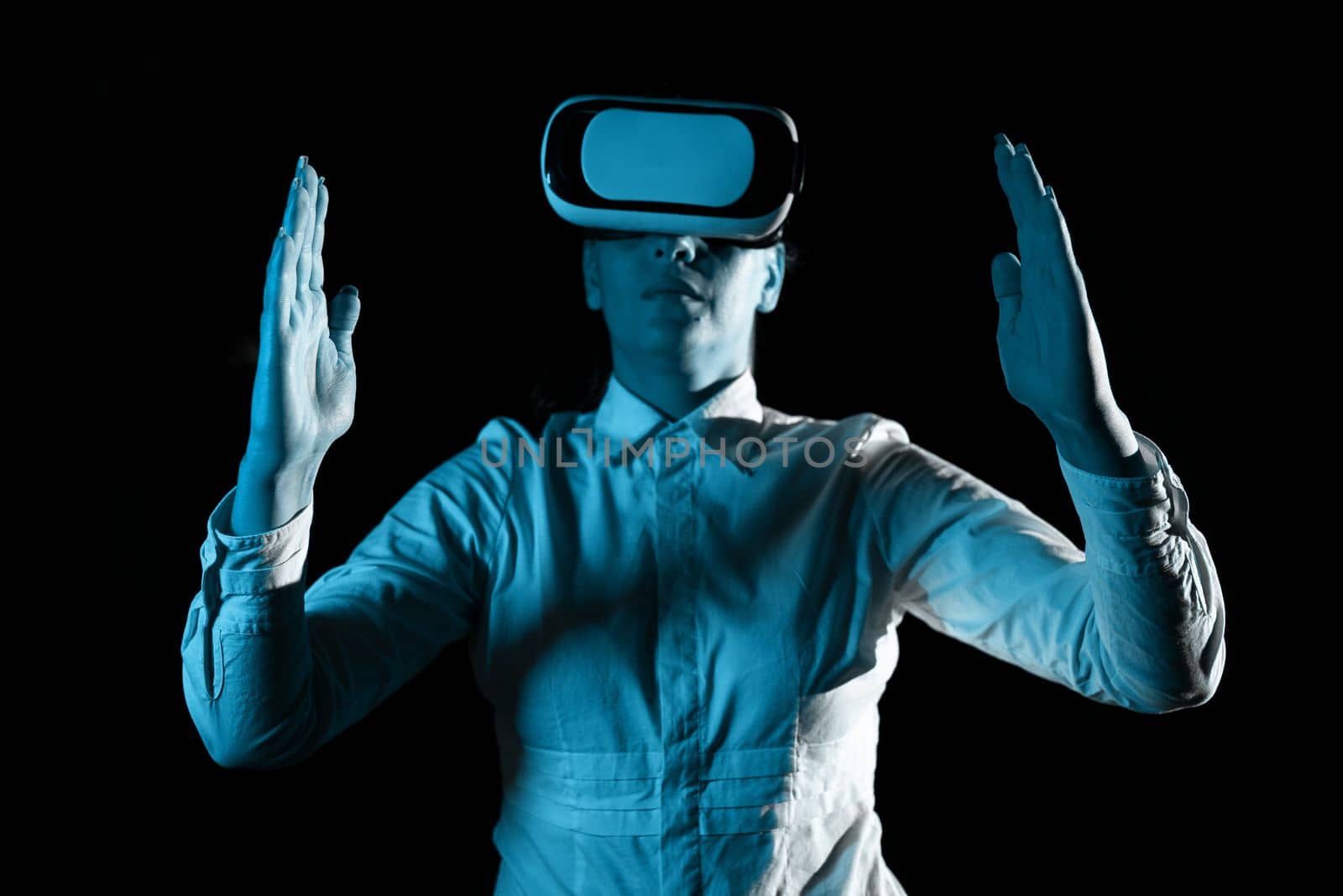 Woman Wearing Vr Glasses And Presenting Important Messages Over Both Hands. Businesswoman Having Virtual Reality Eyeglasses And Showing Crutial Informations Above Two Palms. by nialowwa