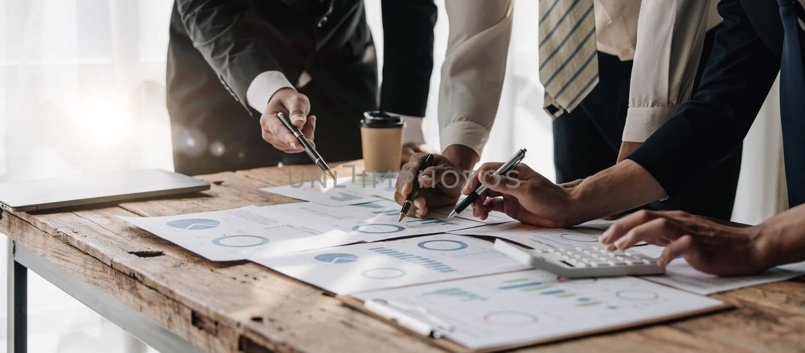 Business People Meeting using laptop computer,calculator,notebook,stock market chart paper for analysis Plans to improve quality next month.