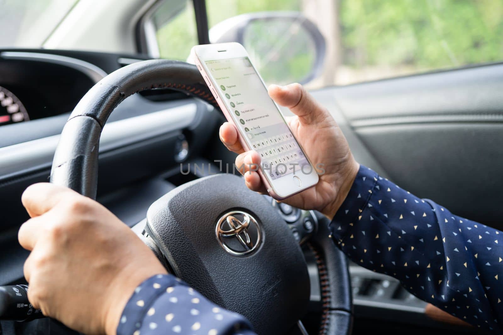 Bangkok, Thailand, July 1, 2022 Holding iPhone in toyota sienta car to communication with family and friends. by pamai