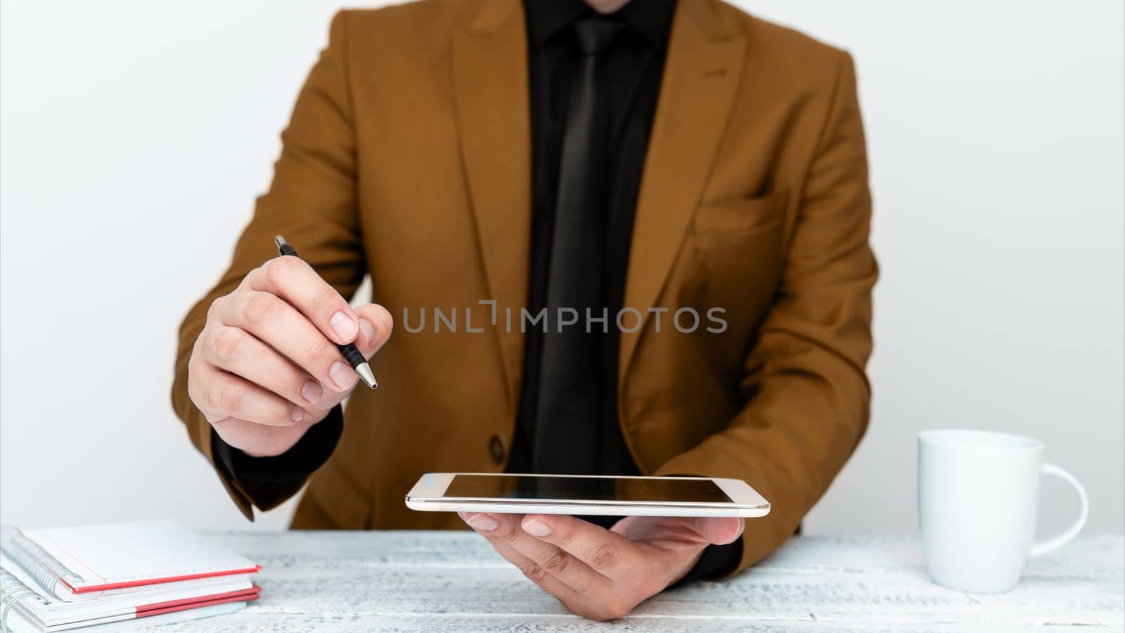 Man in jacket sitting at white table And Pointing With Pen On Message.