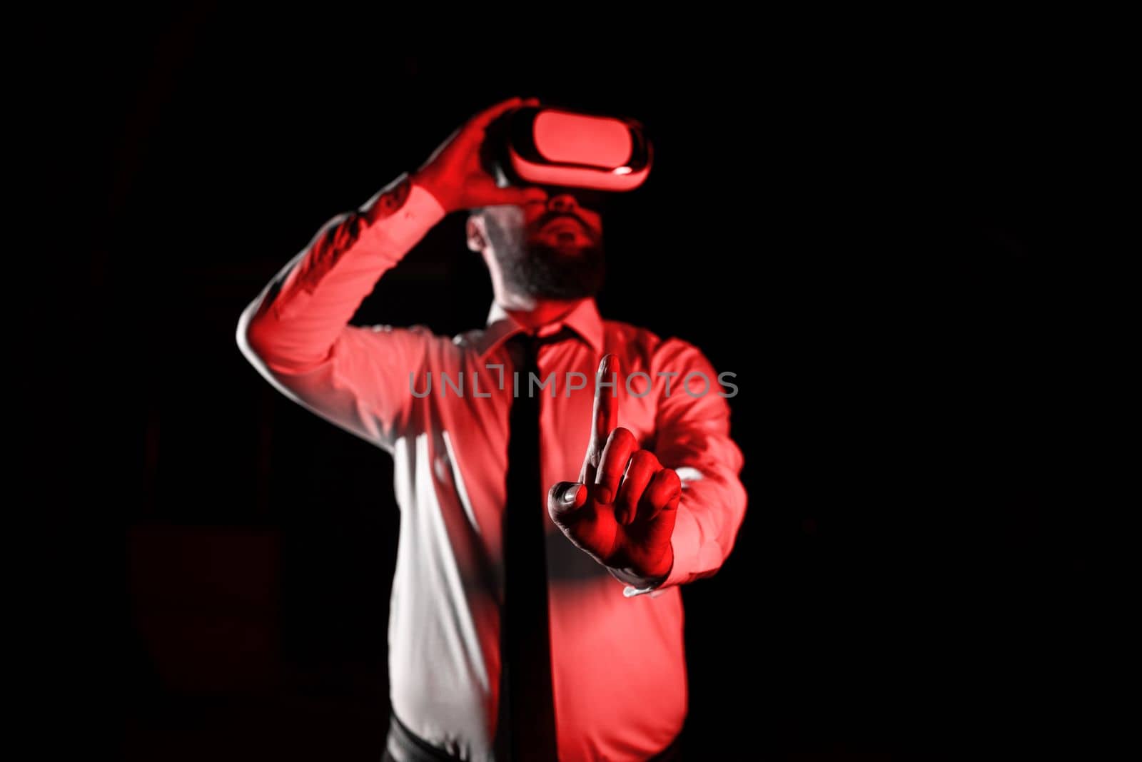 Man Wearing Vr Glasses And Pointing On Important Messages With One Finger. Businessman Having Virtual Reality Eyeglasses And Showing Crutial Informations. by nialowwa