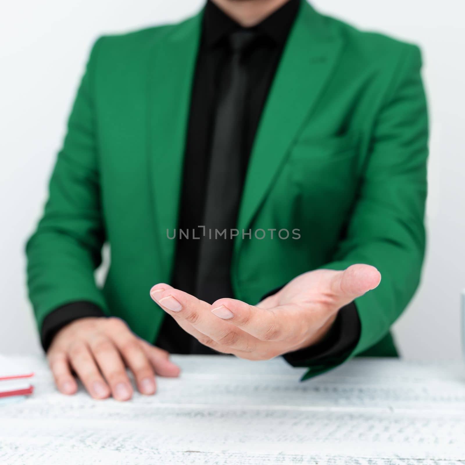 Businessman in Green jacket Holding Important Message In One Hand. Man In Suit Showing New Crutial Idea In Palm. Executive Presenting Updated Critical Information. by nialowwa