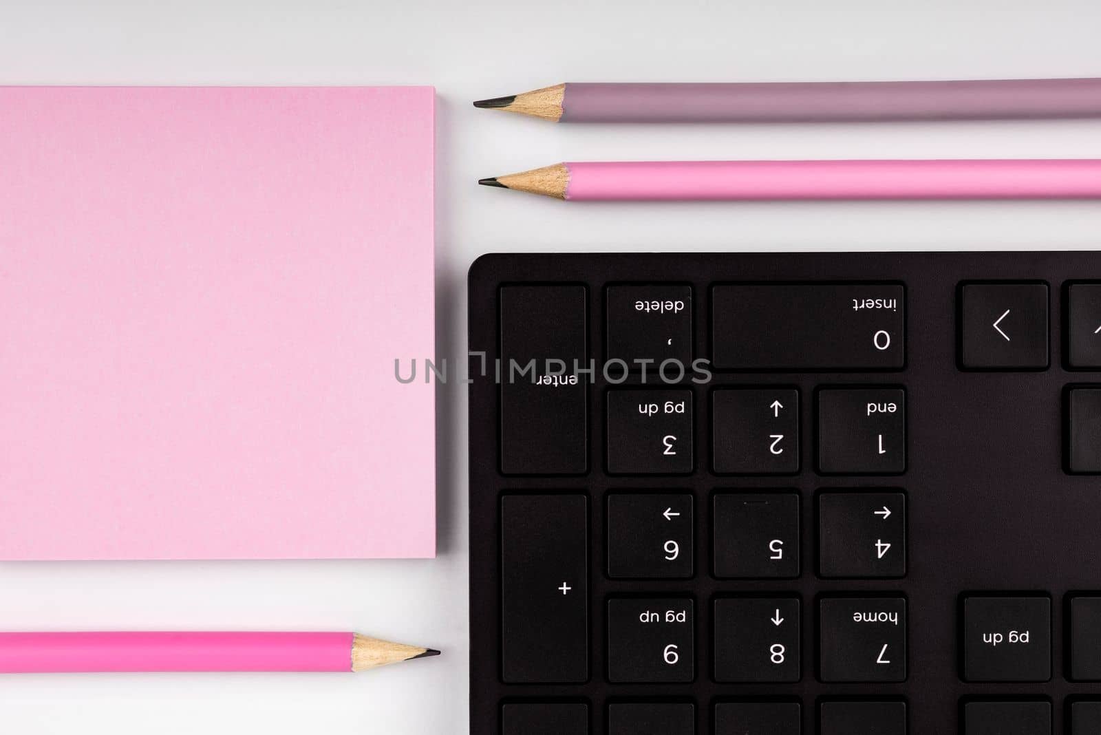 Colored paper with important message lying desk near keyboard. Main information written on notebook. School supplies. Multiple Assorted Collection Office Stationery. by nialowwa