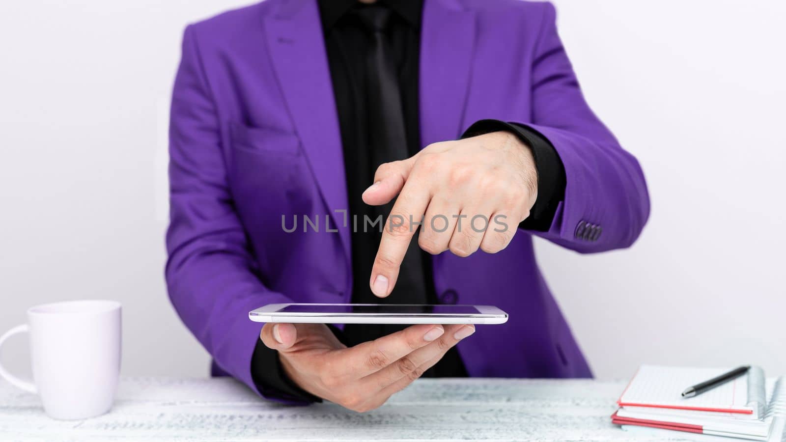 Businessman in a Purple jacket sitting at a table holding a mobile phone