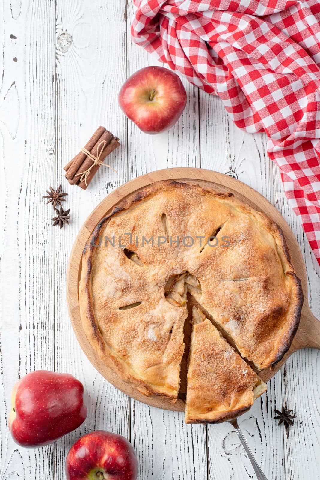 Autumn food. Homemade apple pie with slice with fresh red apples on wooden table