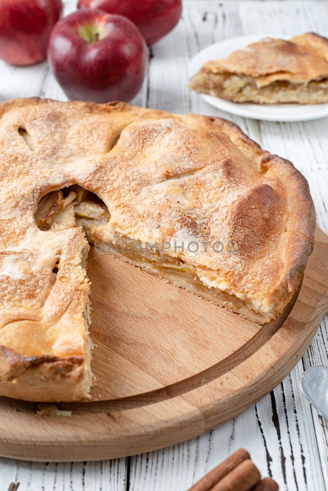 Autumn food. Homemade apple pie with slice with fresh red apples on wooden table