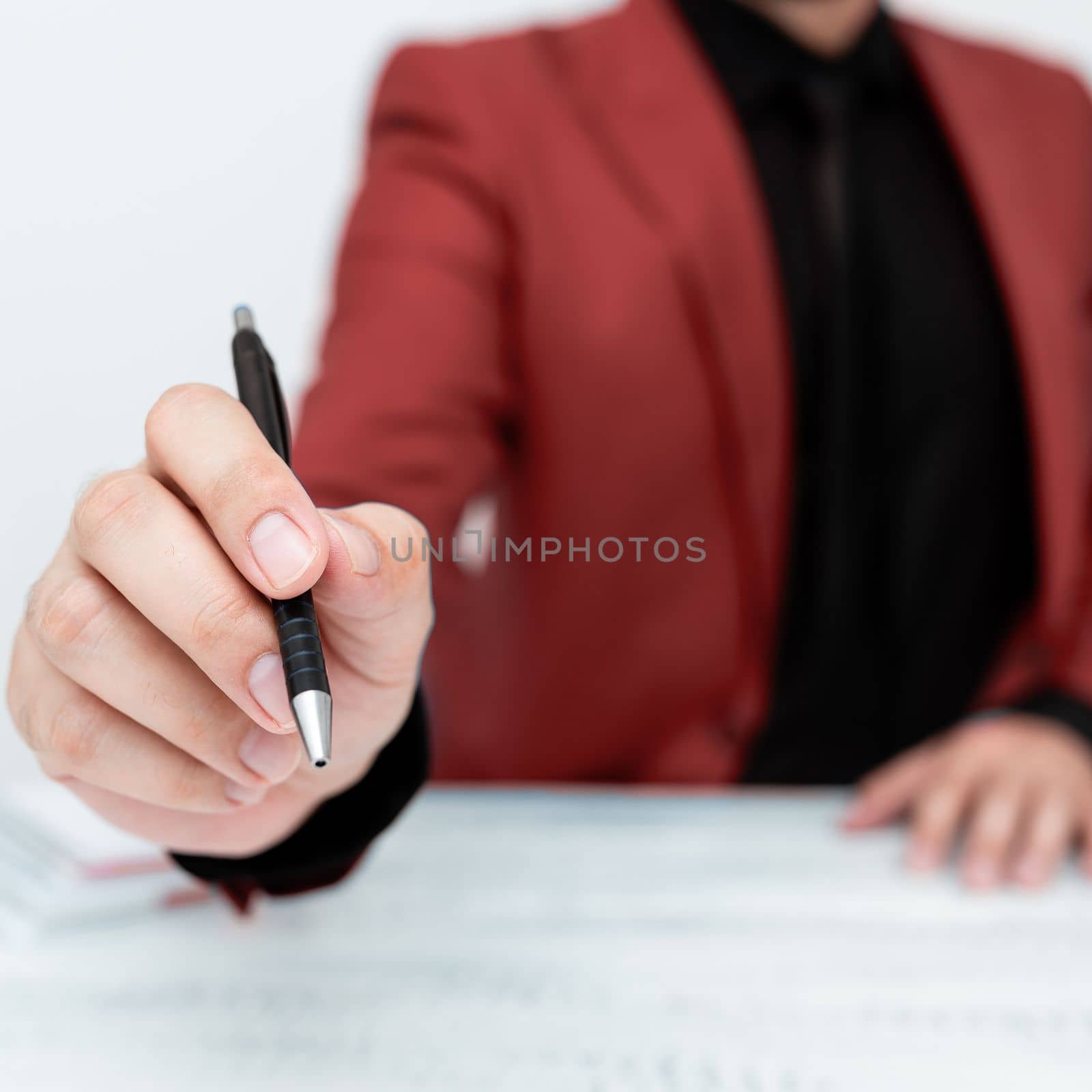 Male mode sitting at table And Pointing With Pen On Important Message.