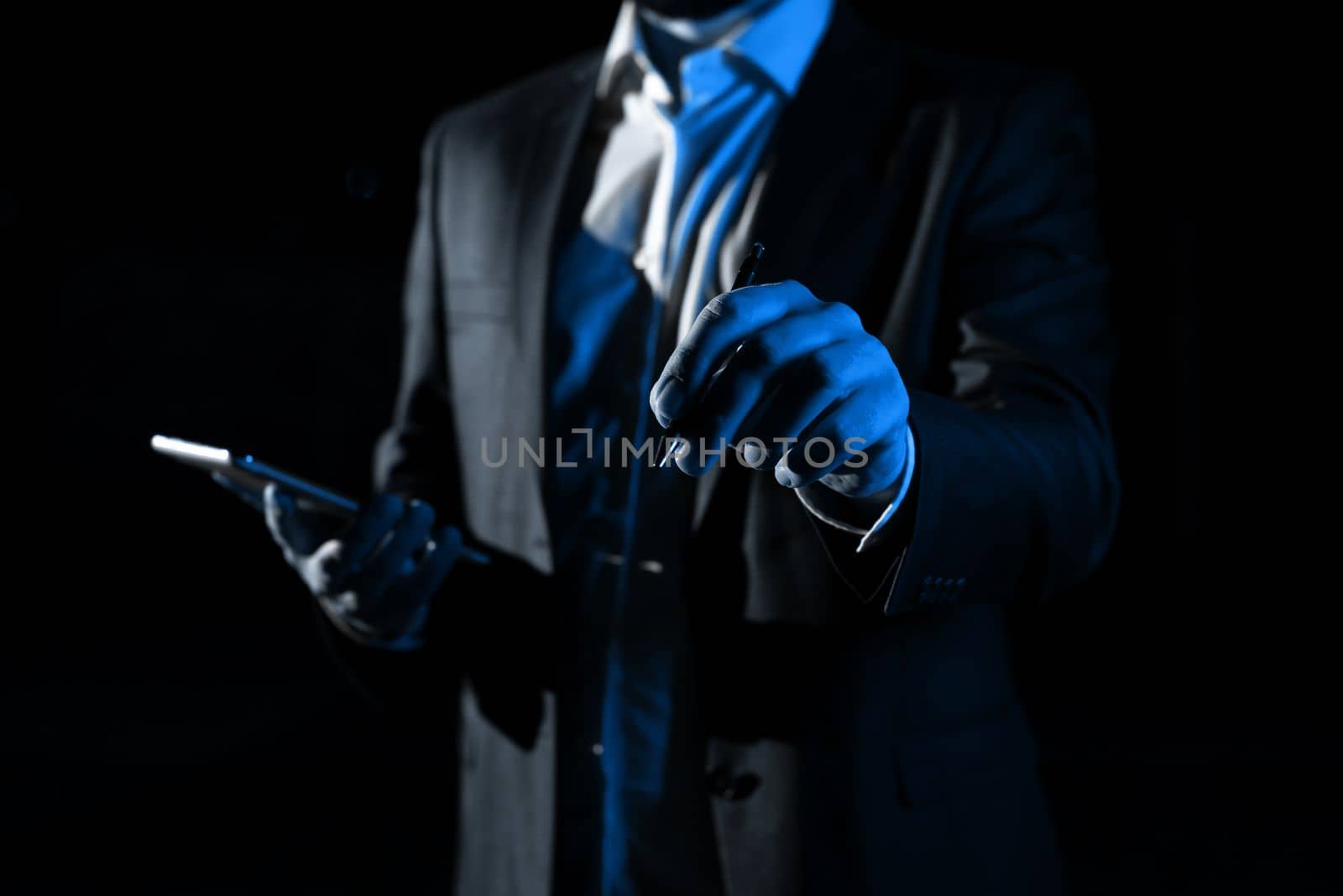 Man Holding Mobile Phone and Pointing On Recent Updates With Pen. Businessman Having Virtual Reality Eyeglasses, Cellphone And Presenting New Idea. by nialowwa