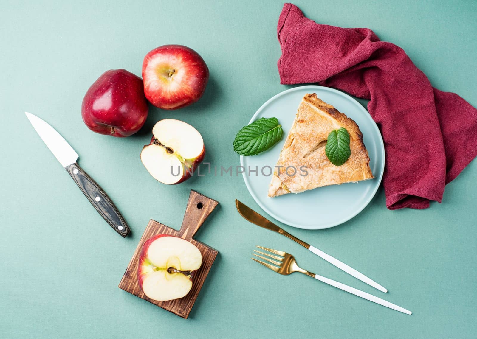 Autumn food. Homemade piece of apple pie with fresh red apples on green table