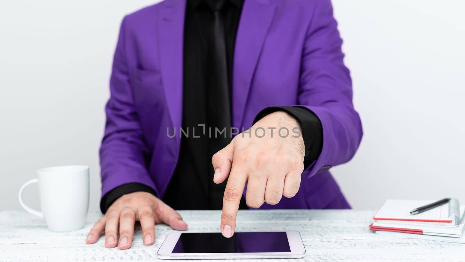 Businessman in Purple jacket sitting at table And Pointing With One Finger On Important Message on the mobile phone. Gentleman Showing Critical Announcement. by nialowwa