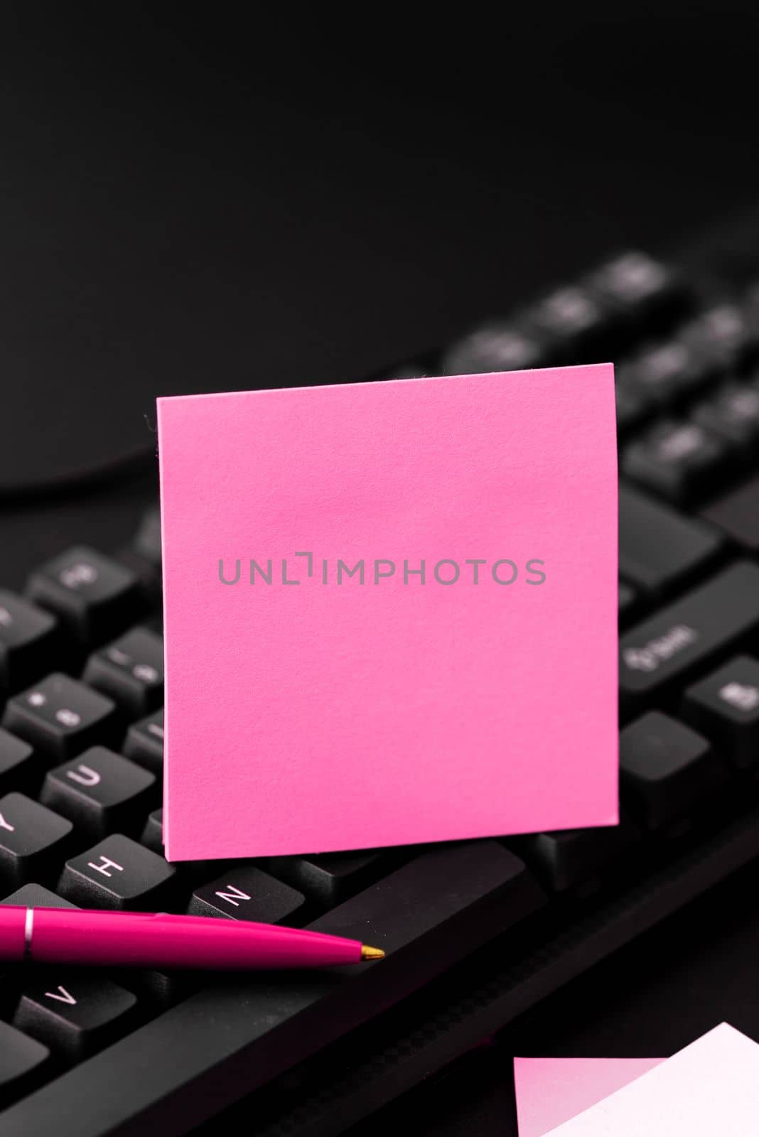 Colored sticker lying on black keyboard. Important information written over paper. Image with school supplies. Multiple Assorted Collection Office Stationery. by nialowwa