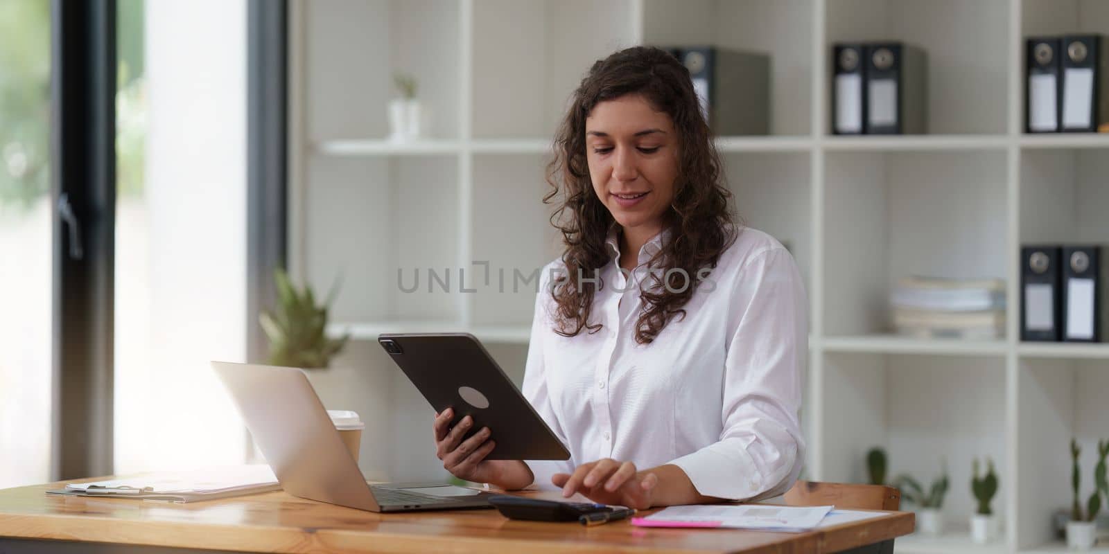 Business woman working at home office and analyze financial report document. Accounting and Finance concept by itchaznong