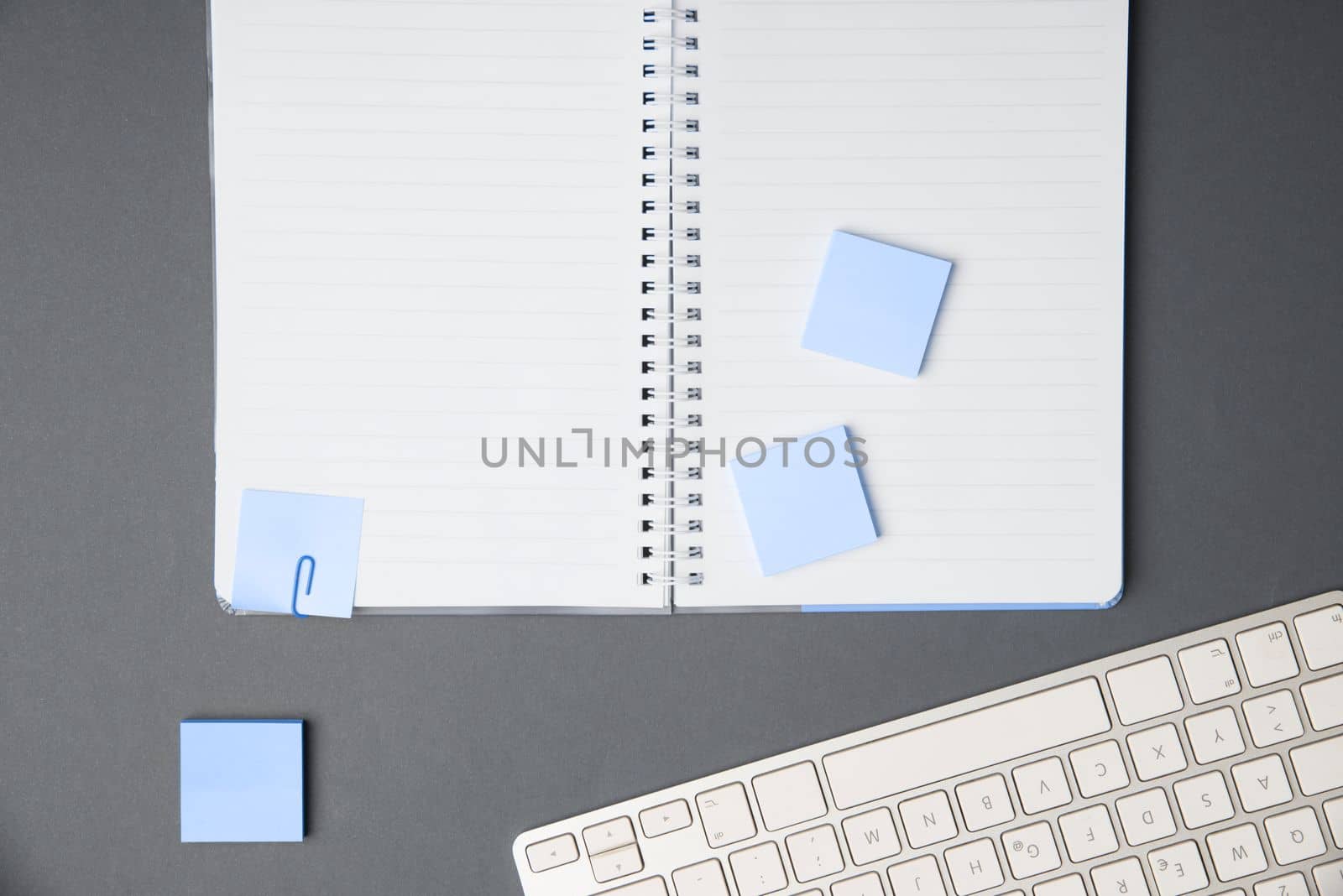 Colored paper with important message lying desk near keyboard. Main information written on notebook. School supplies. Multiple Assorted Collection Office Stationery. by nialowwa