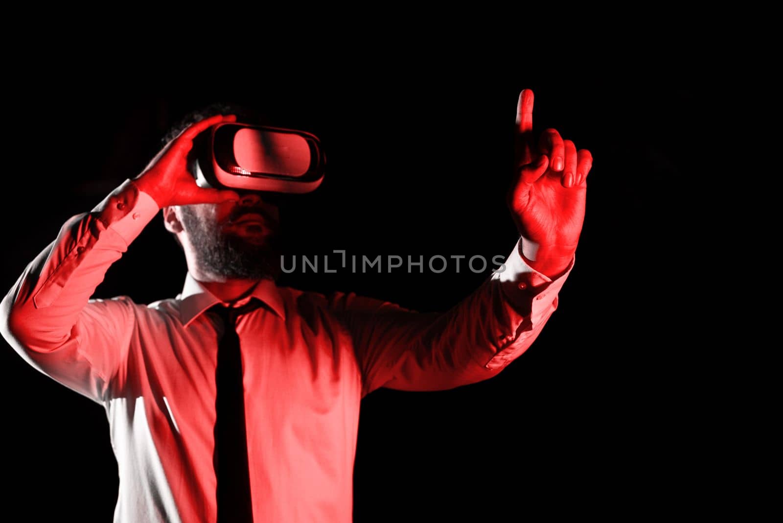 Man Wearing Vr Glasses And Pointing On Important Messages With One Finger. Businessman Having Virtual Reality Eyeglasses And Showing Crutial Informations. by nialowwa