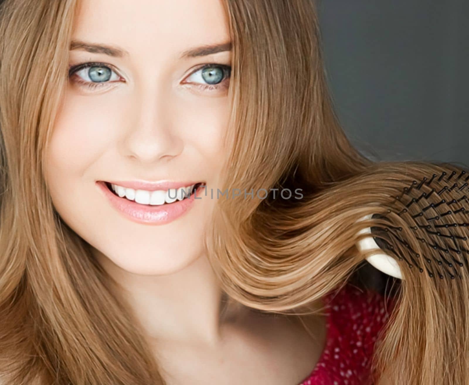 Beautiful happy woman combing her long hair.