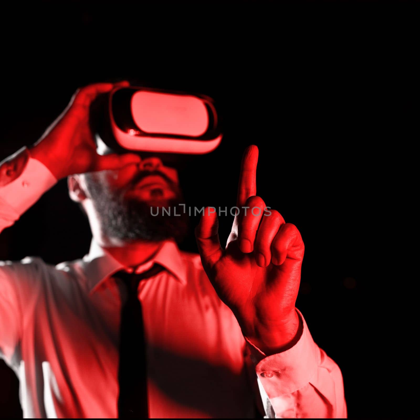 Man Wearing Vr Glasses And Pointing On Important Messages With One Finger. Businessman Having Virtual Reality Eyeglasses And Showing Crutial Informations. by nialowwa