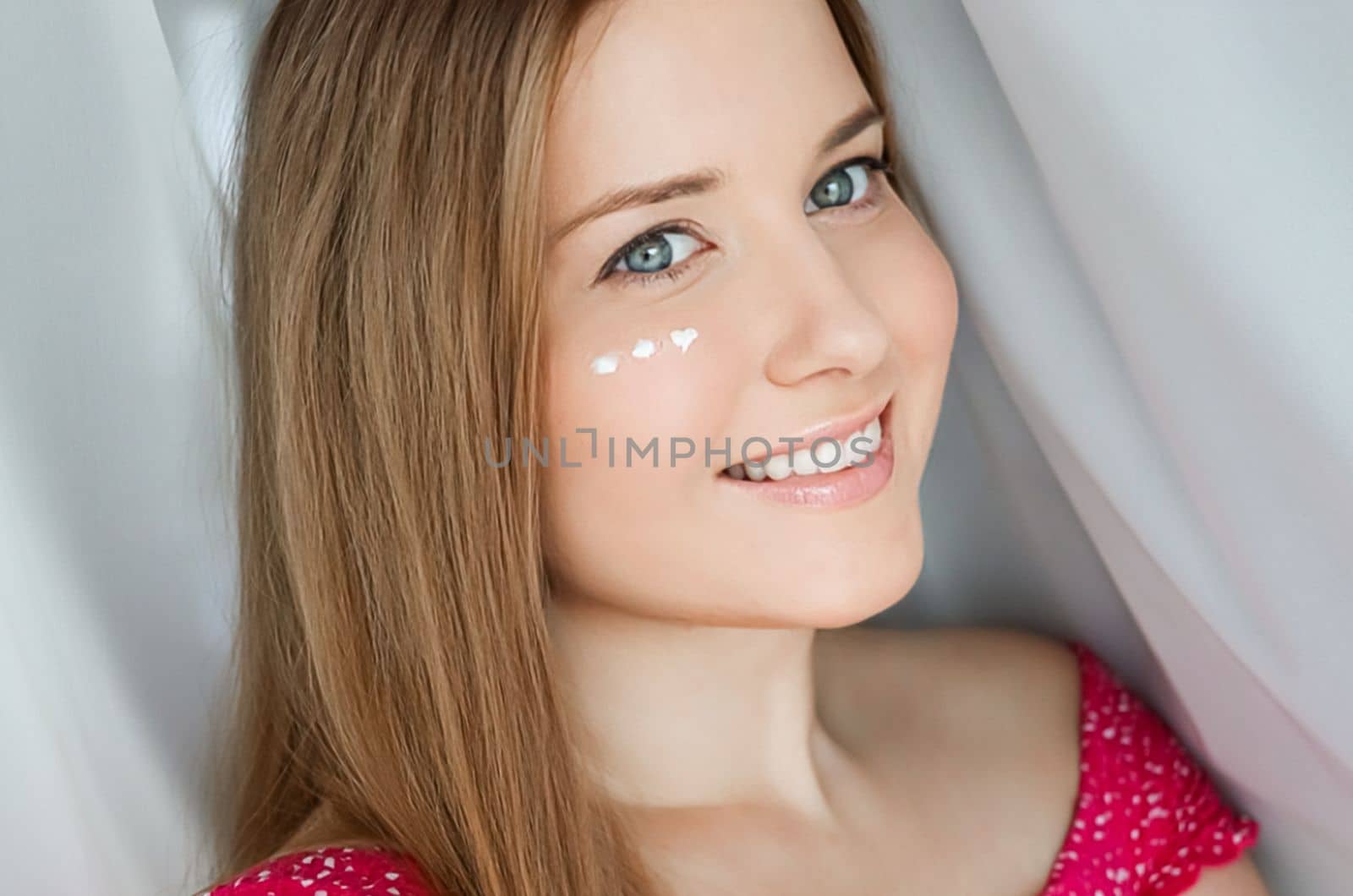 Beautiful woman with skincare cream on her face by Anneleven