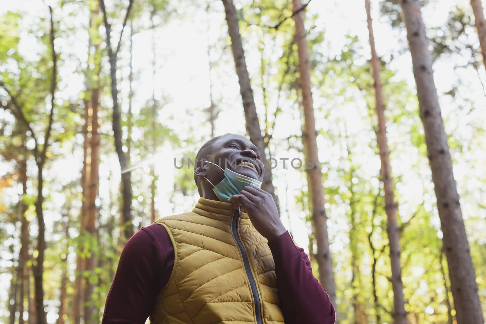 Handsome african american man wearing casual clothes and medical mask smiling happy walking in city park copy space - end of pandemic by Satura86