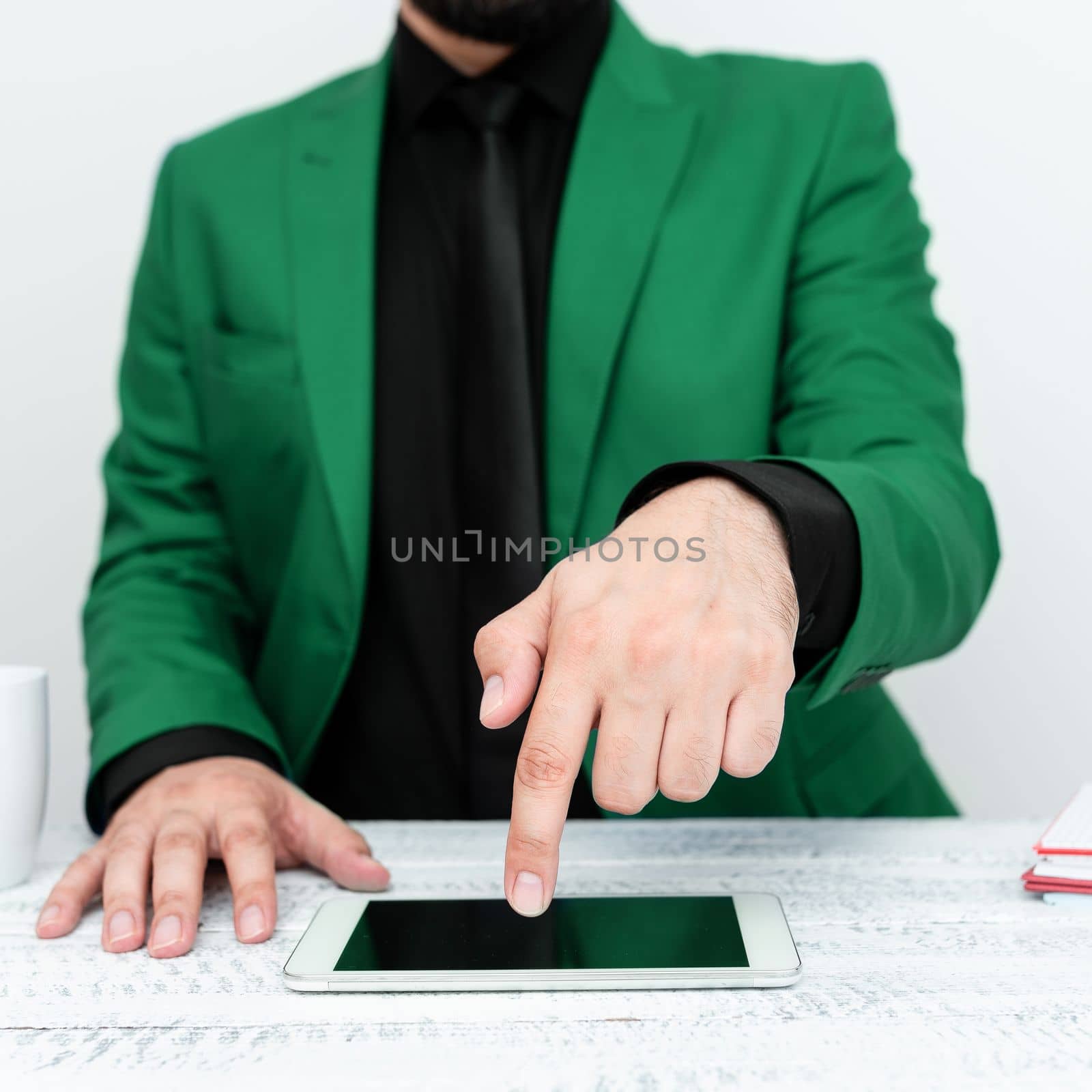 Businessman in Green jacket sitting at table And Pointing With One Finger On Important Message on the mobile phone. Gentleman Showing Critical Announcement. by nialowwa