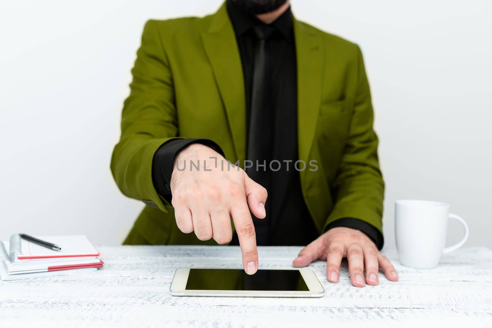 Businessman in Green jacket sitting at table And Pointing With One Finger On Important Message on the mobile phone. Gentleman Showing Critical Announcement. by nialowwa