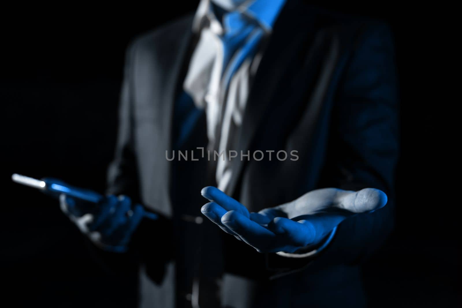 Man Holding Mobile Phone and Holding On Recent Updates With One Hand. Businessman Having Virtual Reality Eyeglasses, Cellphone And Presenting New Idea. by nialowwa