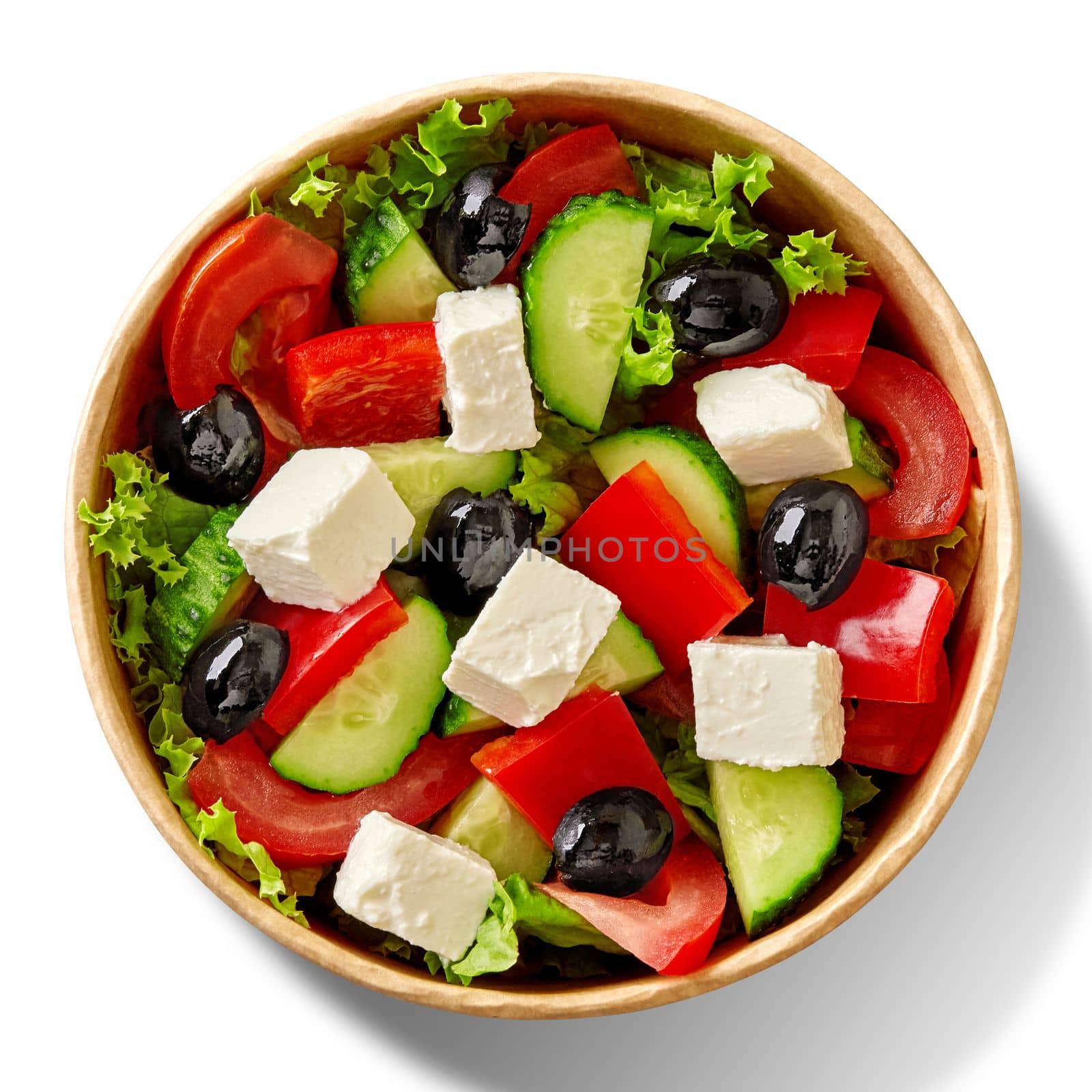 Fresh Greek salad with green lettuce, pieces of ripe tomatoes, sweet peppers, cucumbers, slightly salty creamy feta cheese and marinated black olives served in cardboard bowl. Healthy takeaway food
